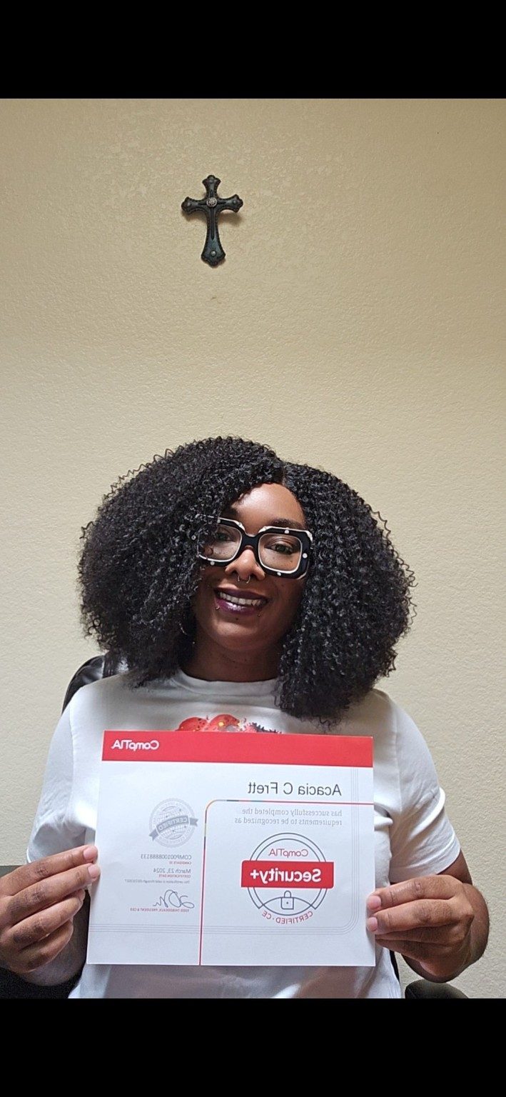Acacia Frett smiling while holding her CompTIA Security+ certification